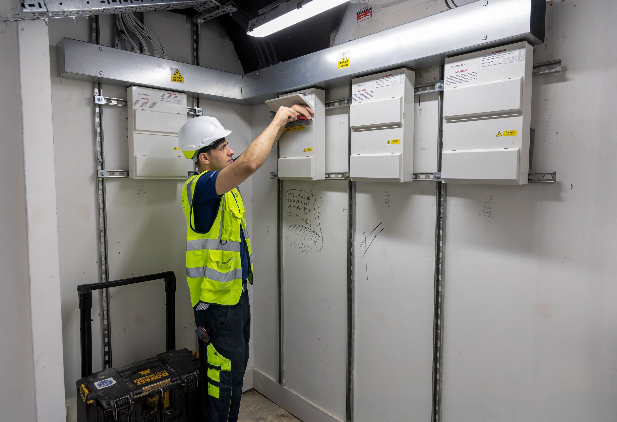 Electrician working on a bank of commercial distribution boards